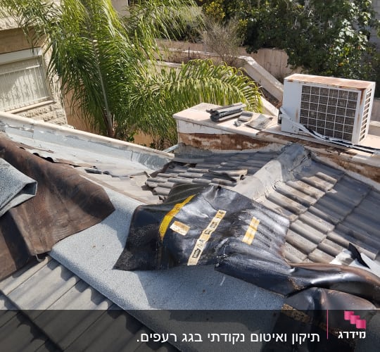 חומרים וכלים על גג רעפים בתהליך תיקון